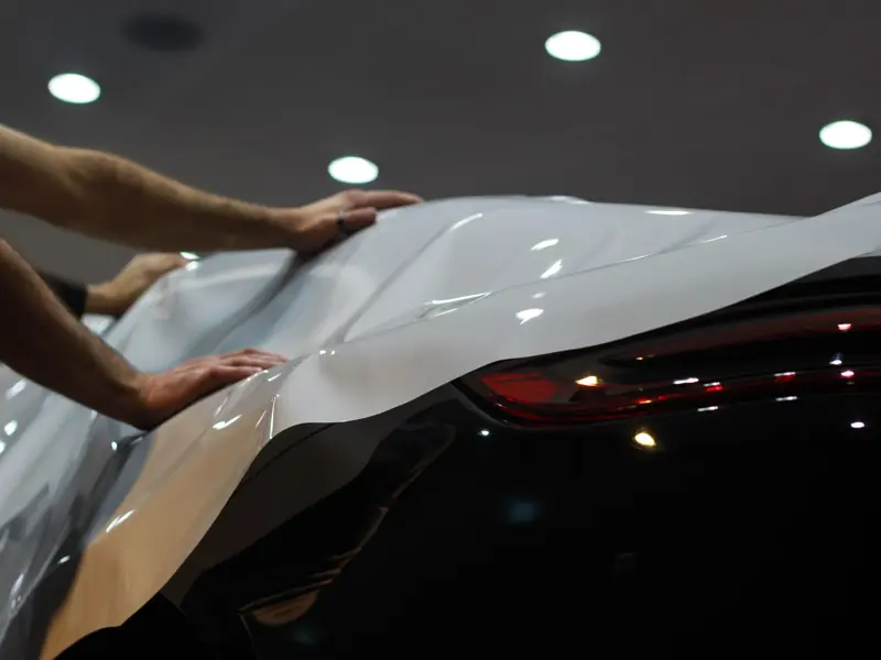 Professional car wrapping in progress, showcasing sleek modern vehicle enhancement.