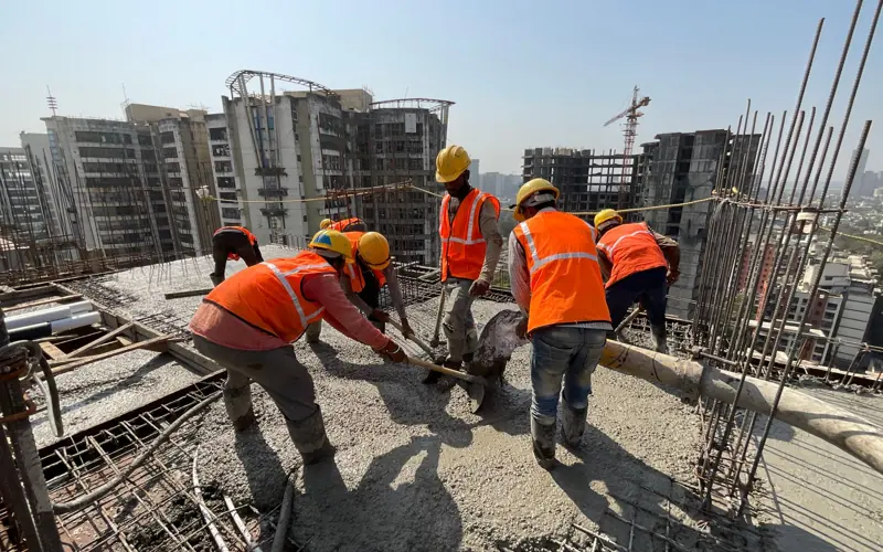 Construction workers pouring concrete on a high-rise building in Mumbai, India.