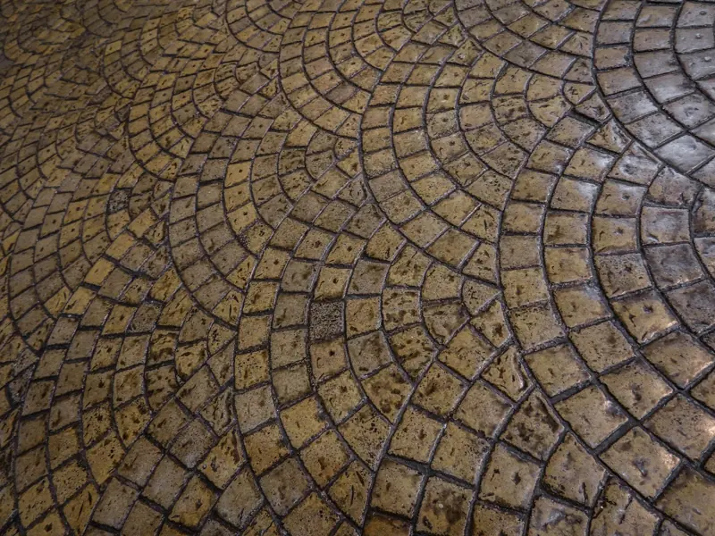 Close-up of a detailed cobblestone floor with an intricate circular pattern, perfect for backgrounds or design inspiration.