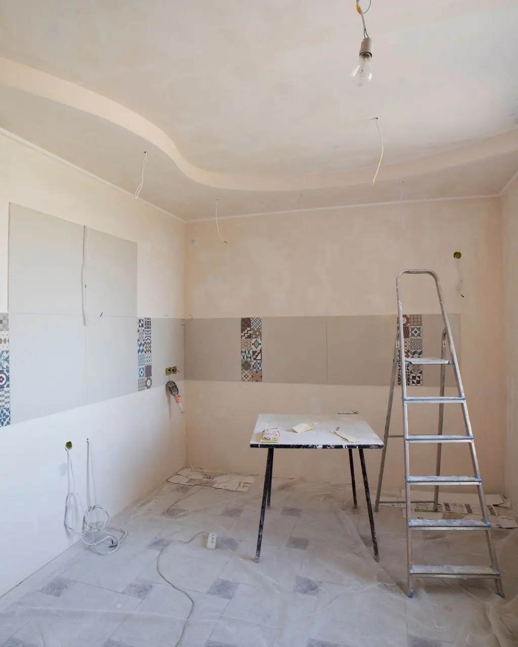 Spacious kitchen under renovation with ladder and tools, showcasing a fresh new design.