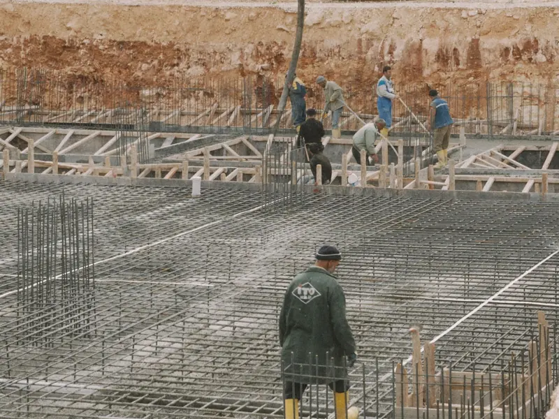 Workers building a foundation with rebar at a construction site.
