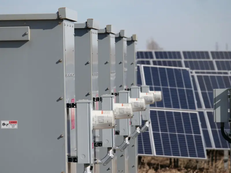 Close-up of electrical boxes and solar panels harnessing solar energy outdoors.