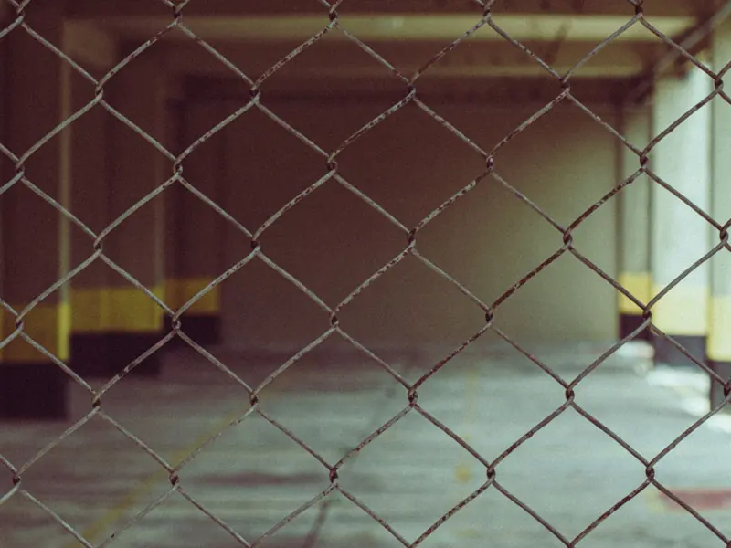 Blurred interior view through a chain link fence in industrial setting.