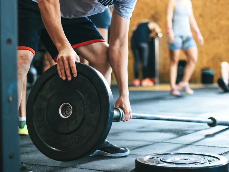 Focused weightlifting session in a gym with diverse athletes participating indoors.