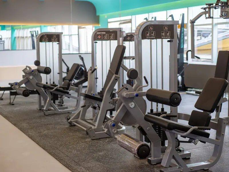 Interior view of a gym with modern exercise equipment for fitness workouts.