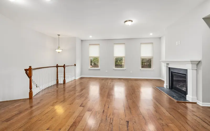Bright and spacious modern living room with wooden floors and a fireplace, perfect for interior design inspiration.
