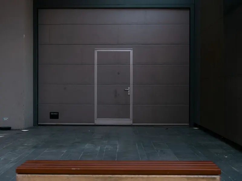 Sleek modern garage door design with a bench in Istanbul, showcasing minimalist architecture.