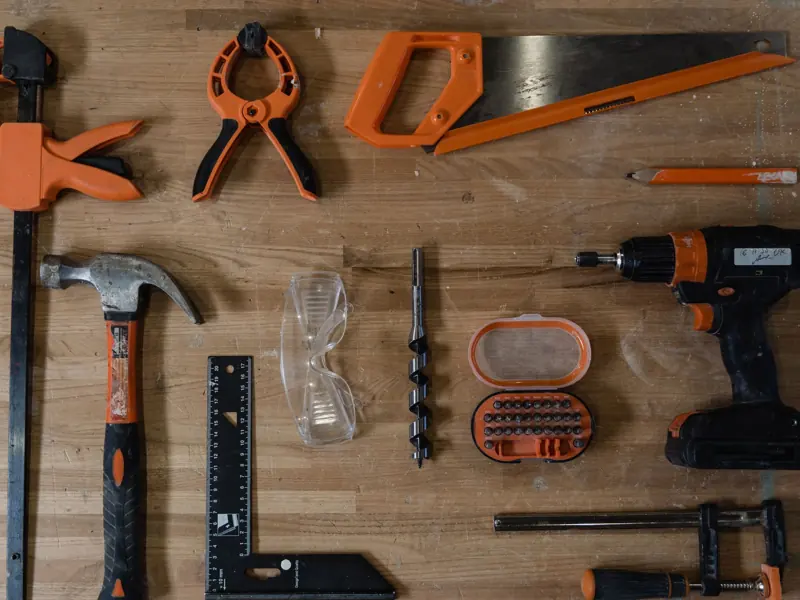 A variety of carpentry tools arranged neatly on a wooden surface, ideal for DIY projects.