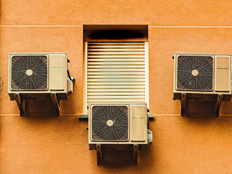 Exterior wall with three air conditioners, showcasing modern architectural elements.