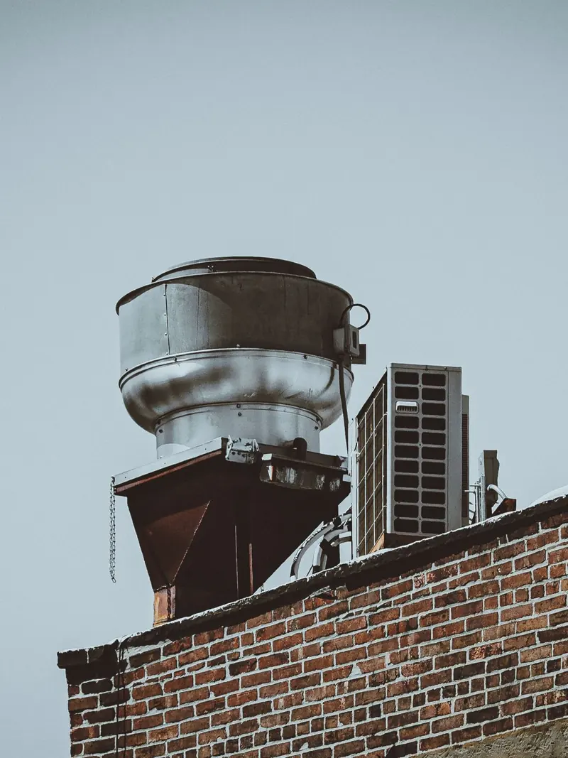 Close-up of rooftop ventilation system on a brick building in New York City.