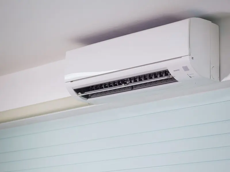 Close-up of a wall-mounted air conditioner indoors, showcasing sleek design for modern cooling solutions.