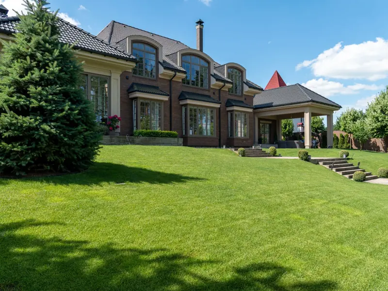 Luxury estate with manicured lawn and modern architectural design on a sunny day.