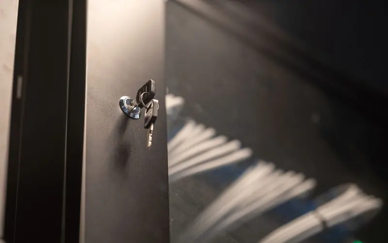 Detailed view of a key inserted into a modern lock on a metal cabinet door.