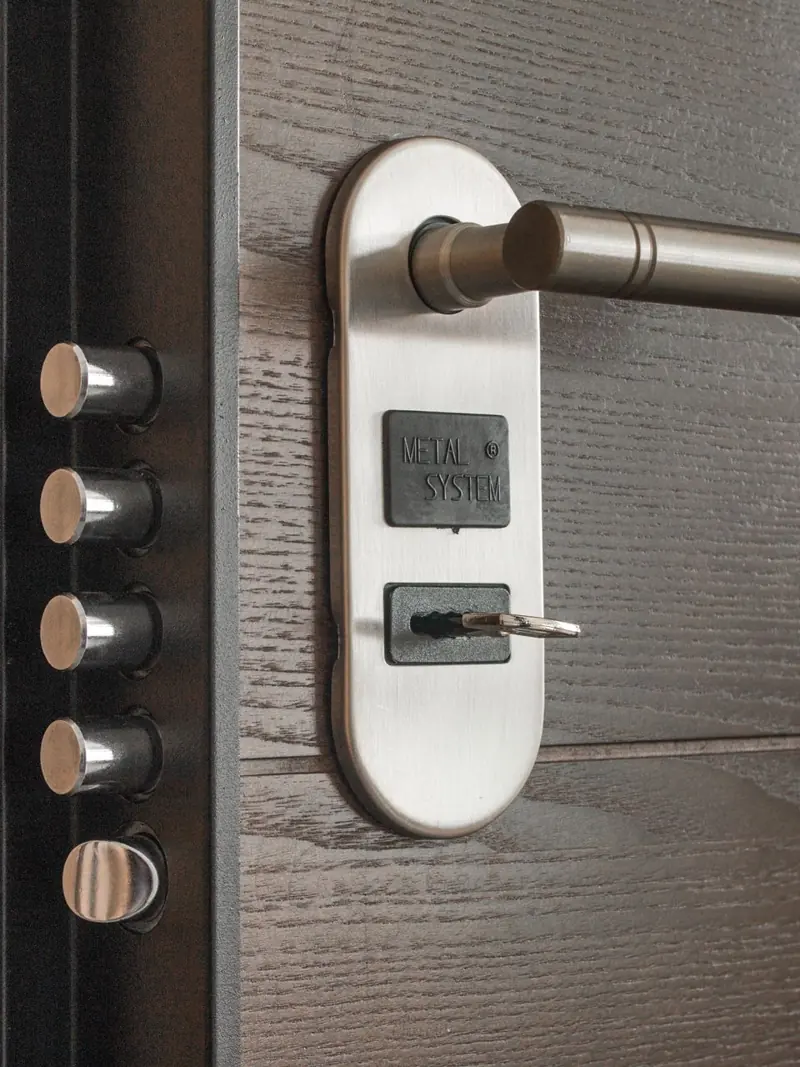 Metal door handle and lock system with key inserted, showcasing security features.