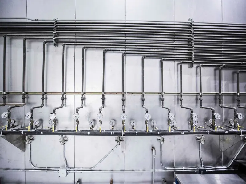 Detailed view of an industrial plumbing system featuring multiple pressure gauges and steel pipes.