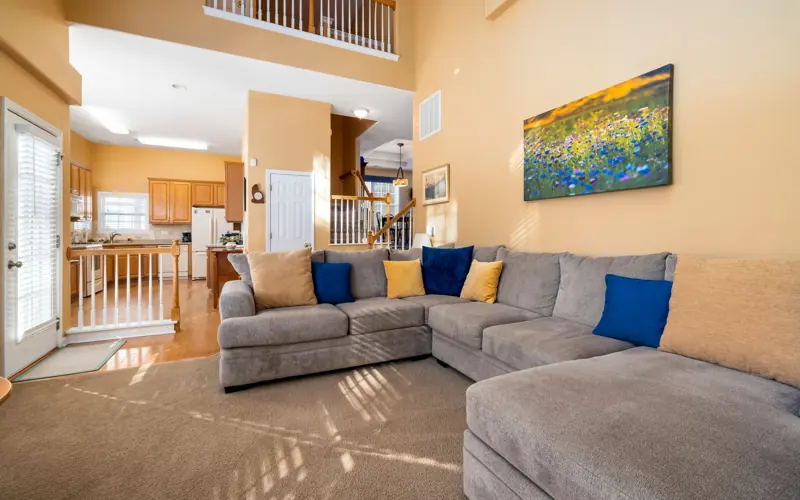 Bright and spacious living room showcasing a cozy grey sofa and modern interior design.