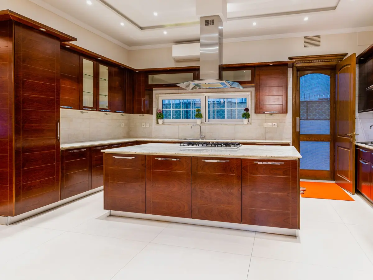 Modern kitchen with dark wood cabinets and marble countertops, emphasizing elegant interior design.