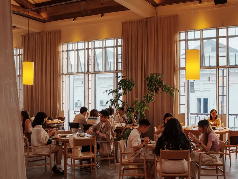 A warm, inviting cafe ambience with people dining in George Town, Malaysia.