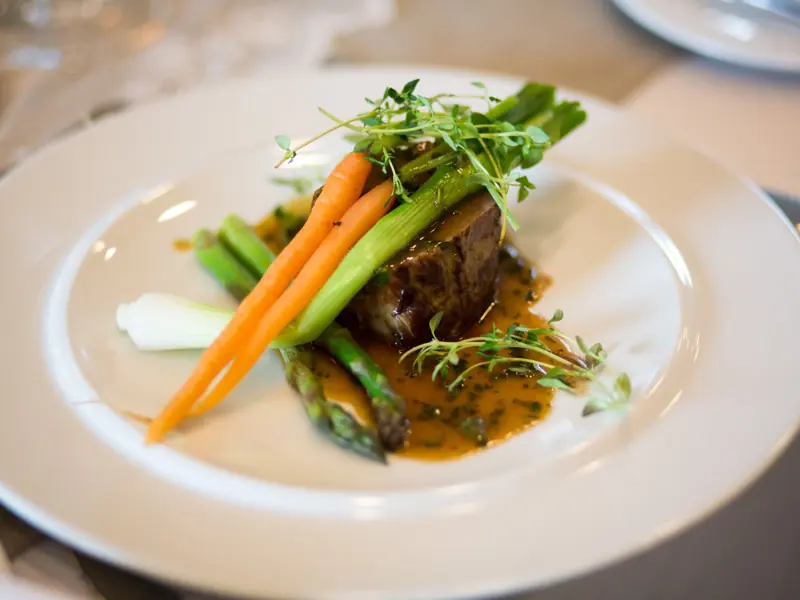 Luxurious gourmet meal elegantly plated with vegetables and sauce.