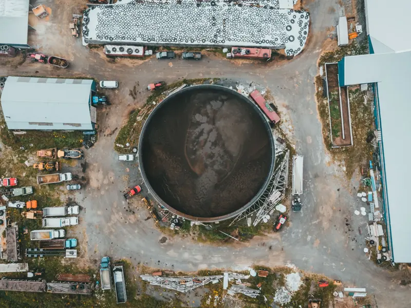 High-angle aerial view of an industrial storage area with diverse vehicles and equipment.